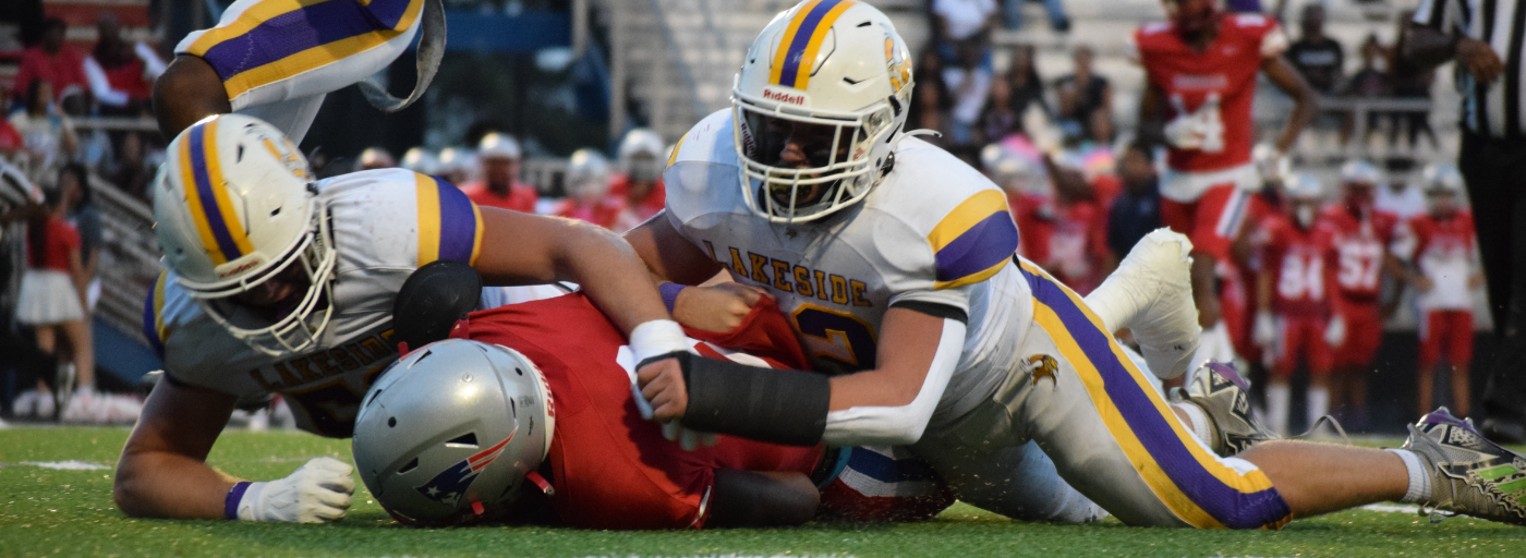 Lakeside High School football players tackle Berkmar. 