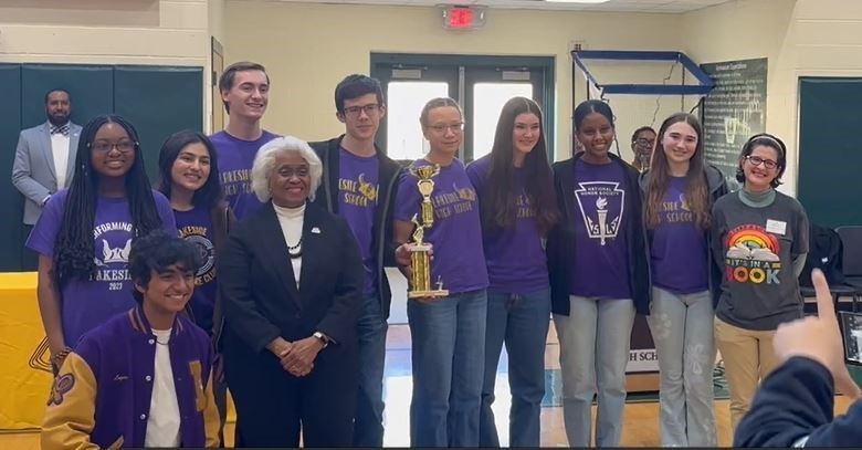 Students from the Lakeside Reading Bowl team holding 1st place trophies. Text reads: congratulations lakeside Reading Bowl Team 1st place 2nd year running