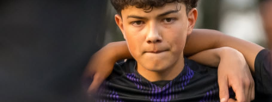 Lakeside Viking soccer athlete with black and purple vertically striped #22 jersey in the huddle